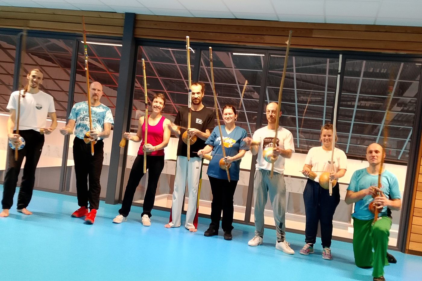 Les élèves alignés dans le gymnase, chacun un berimbau à la main